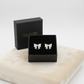 Melchior Jewellery sterling silver bow stud earrings displayed in a black jewellery box on a soft beige cushion