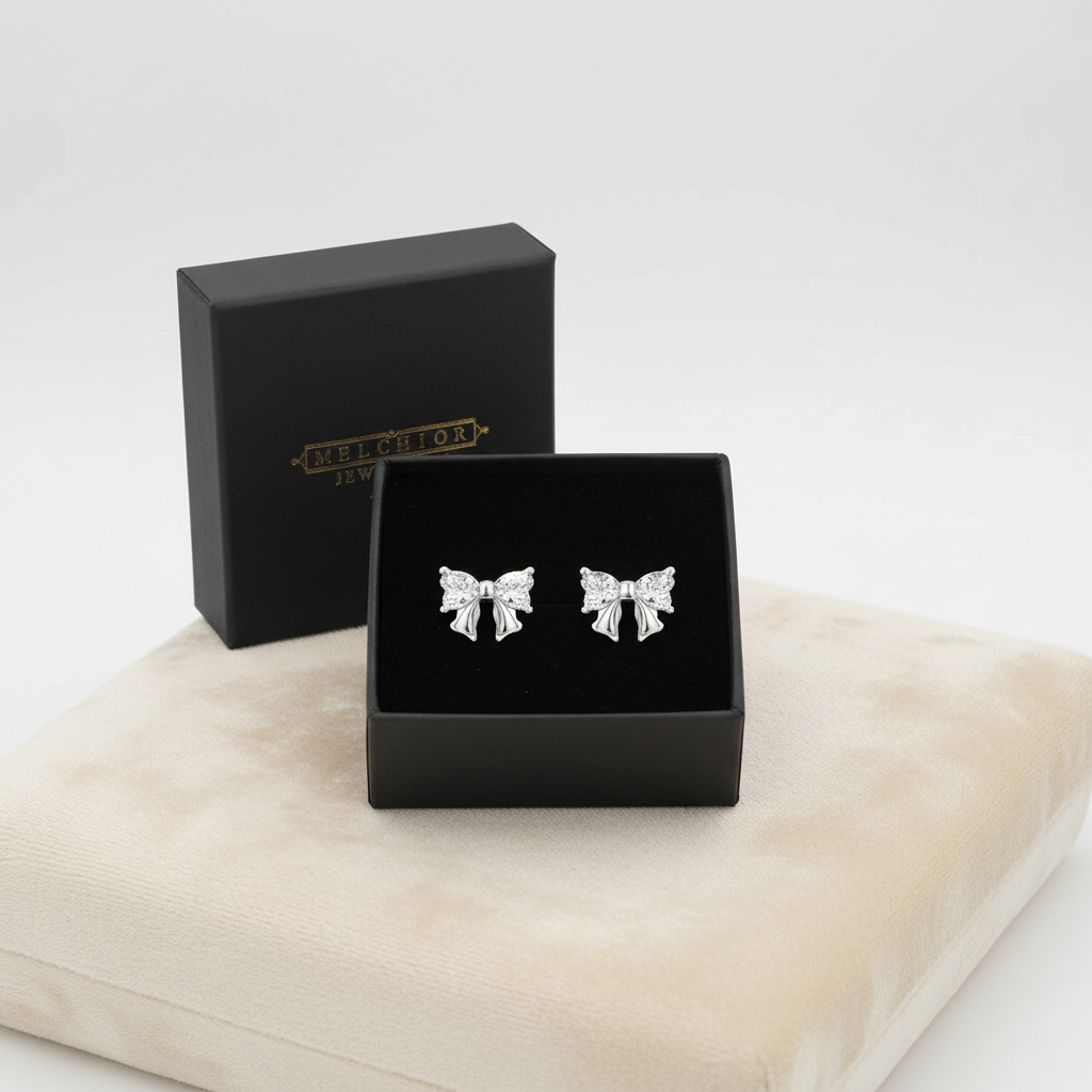 Melchior Jewellery sterling silver bow stud earrings displayed in black gift box on beige cushion