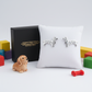 Sterling silver dachshund earrings displayed on white cushion with Melchior Jewellery box and dog toy
