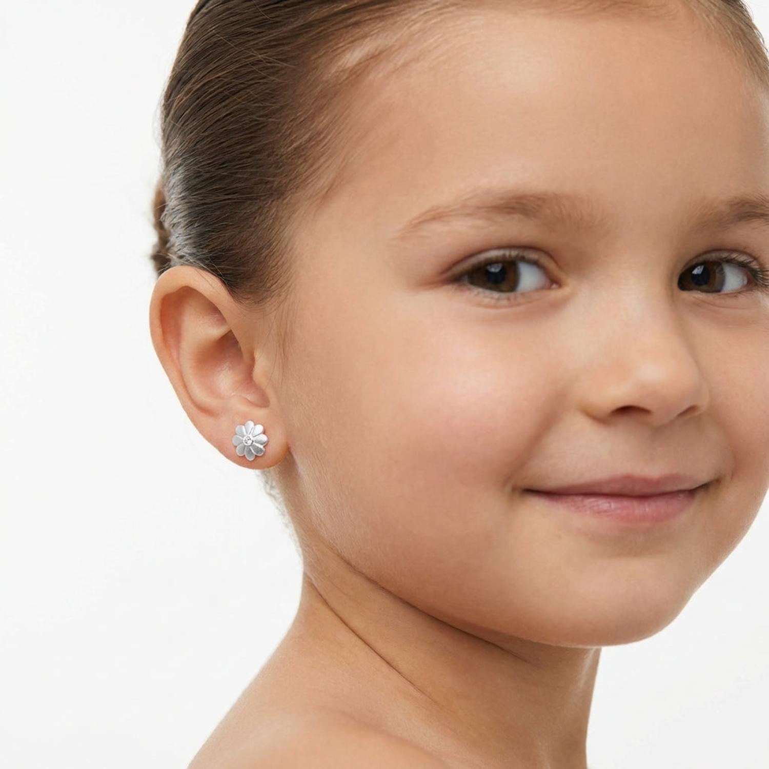 Girl wearing sterling silver flower stud earrings for girls by Melchior Jewellery on white background