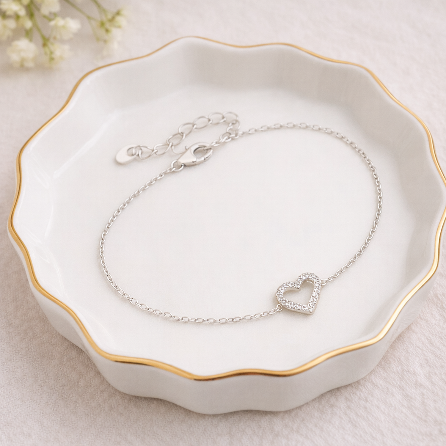 Melchior Jewellery sterling silver heart CZ bracelet with delicate chain on a white dish