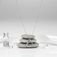 Sterling silver heart necklace for women displayed on stacked grey stones with sparkling accents