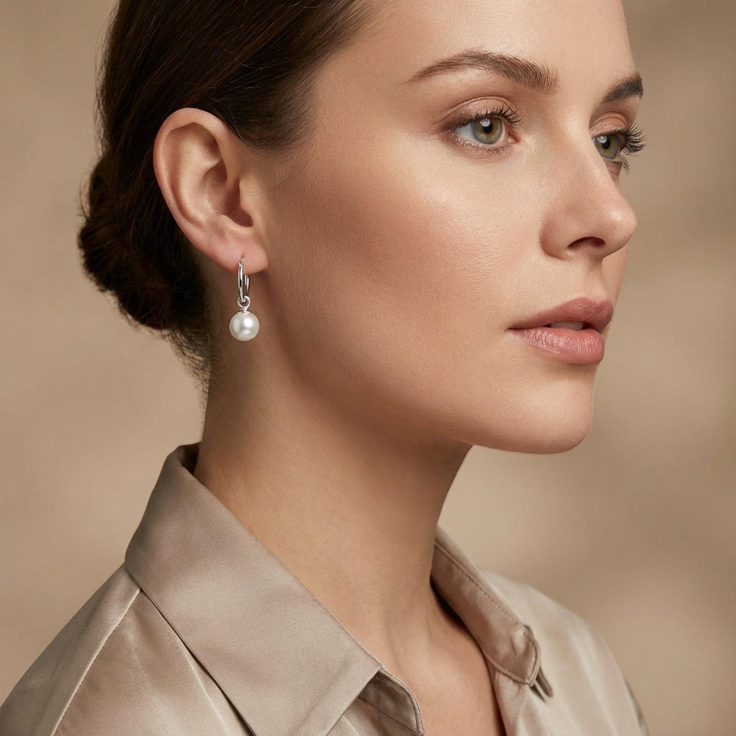 Melchior Jewellery sterling silver pearl hoop earrings worn by woman with elegant neutral outfit