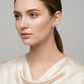 Melchior Jewellery sterling silver pink bow earrings worn by woman with sleek hairstyle and satin top