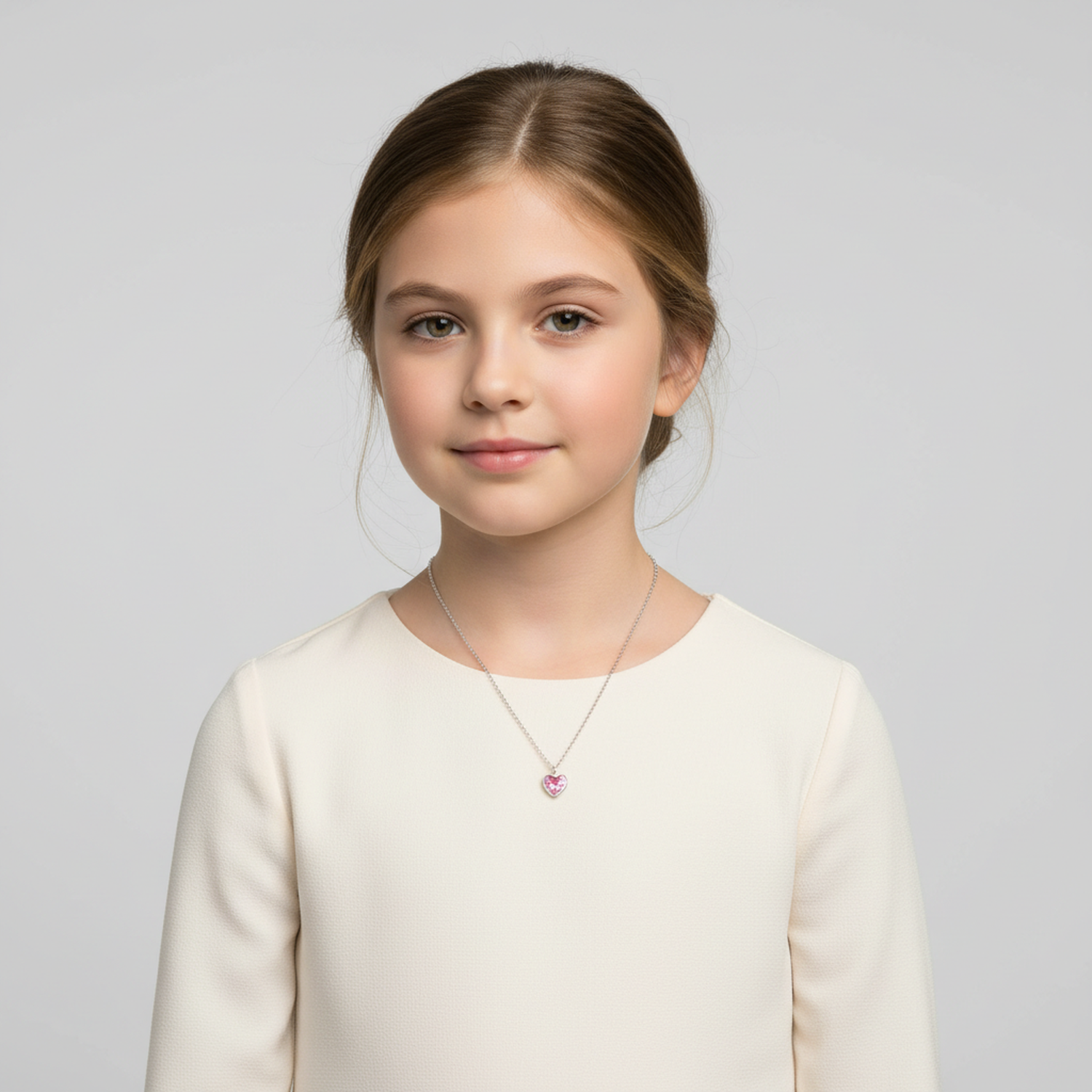 Child wearing Melchior Jewellery sterling silver pink heart necklace with delicate chain and small pink pendant