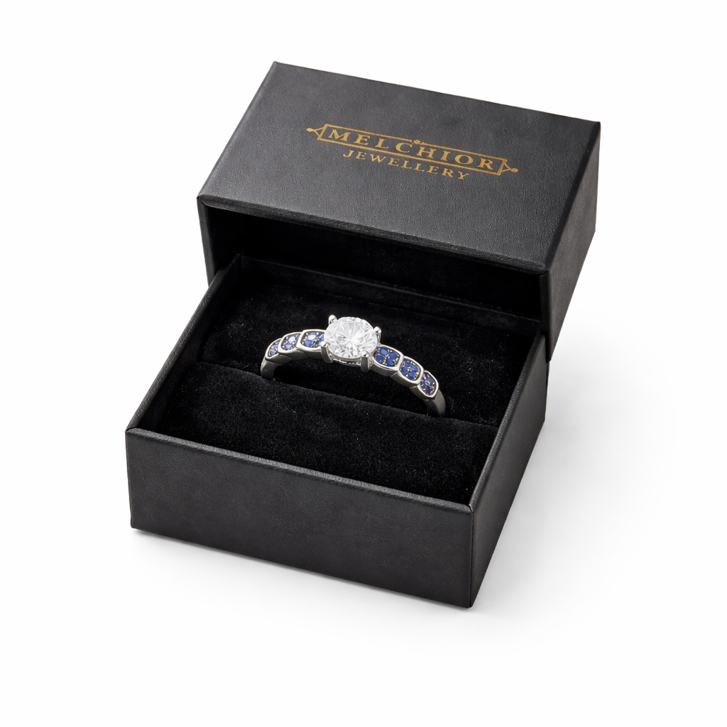 Sterling silver sapphire engagement ring with central diamond in Melchior Jewellery black gift box