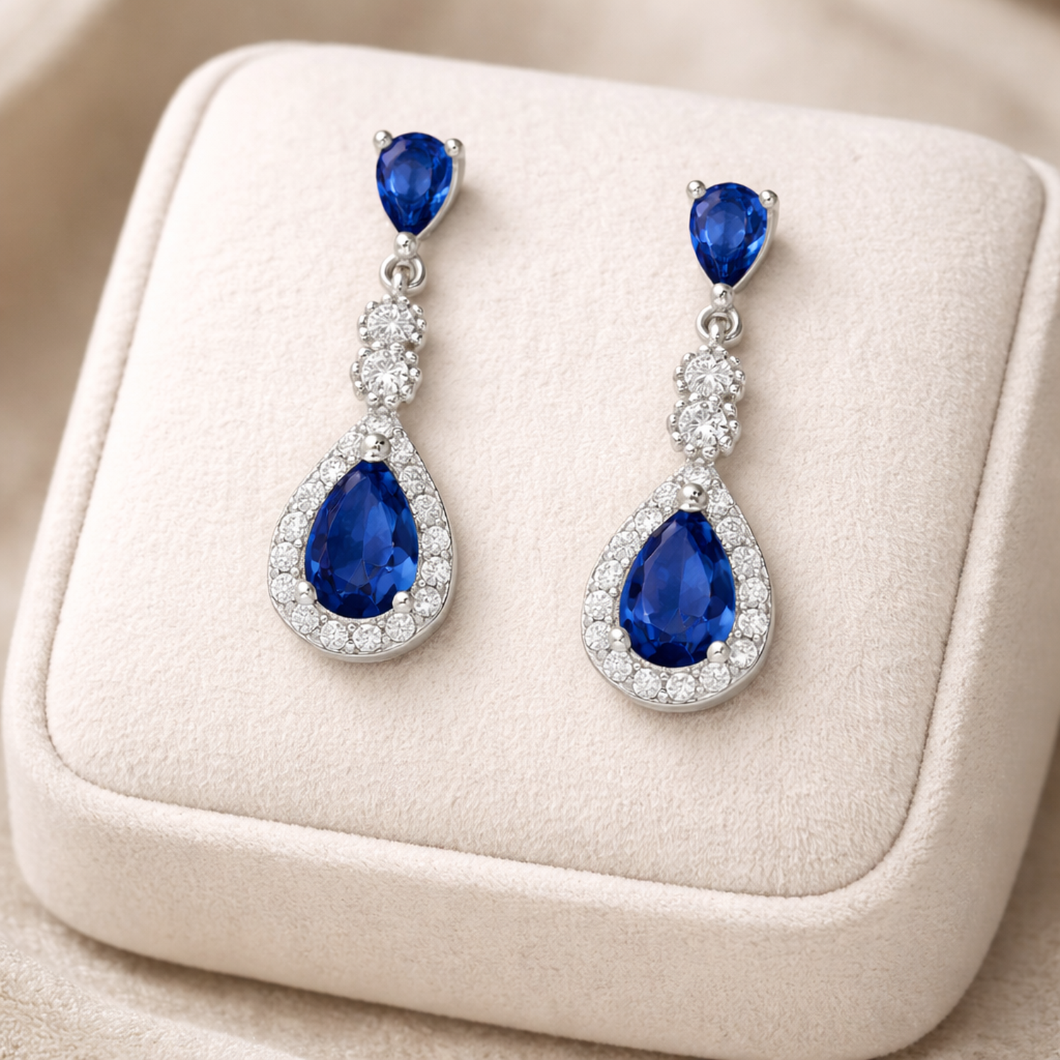 Melchior Jewellery sterling silver sapphire teardrop earrings with sparkling gemstones on a beige display