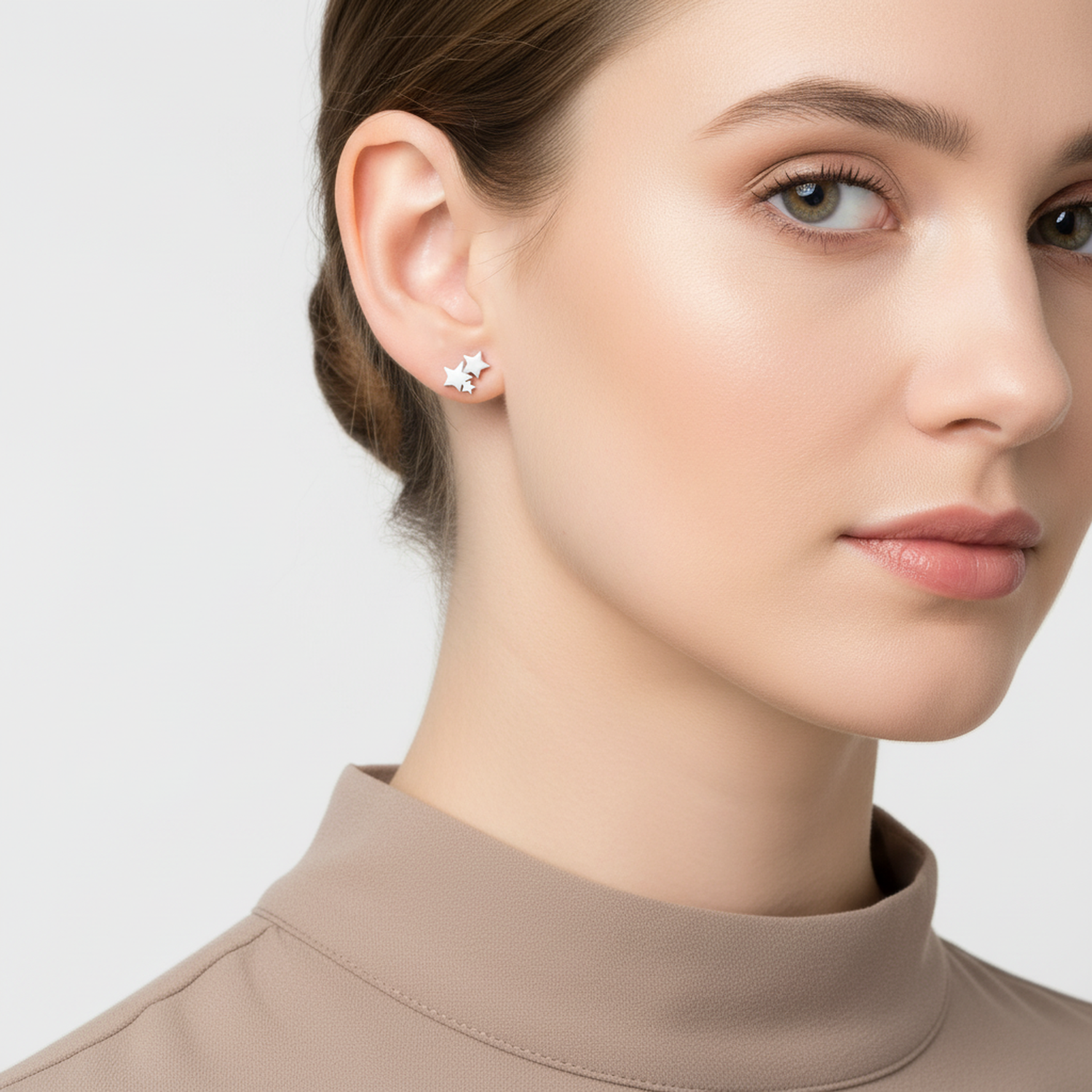 Melchior Jewellery sterling silver star stud earrings worn by woman with neutral makeup and taupe top