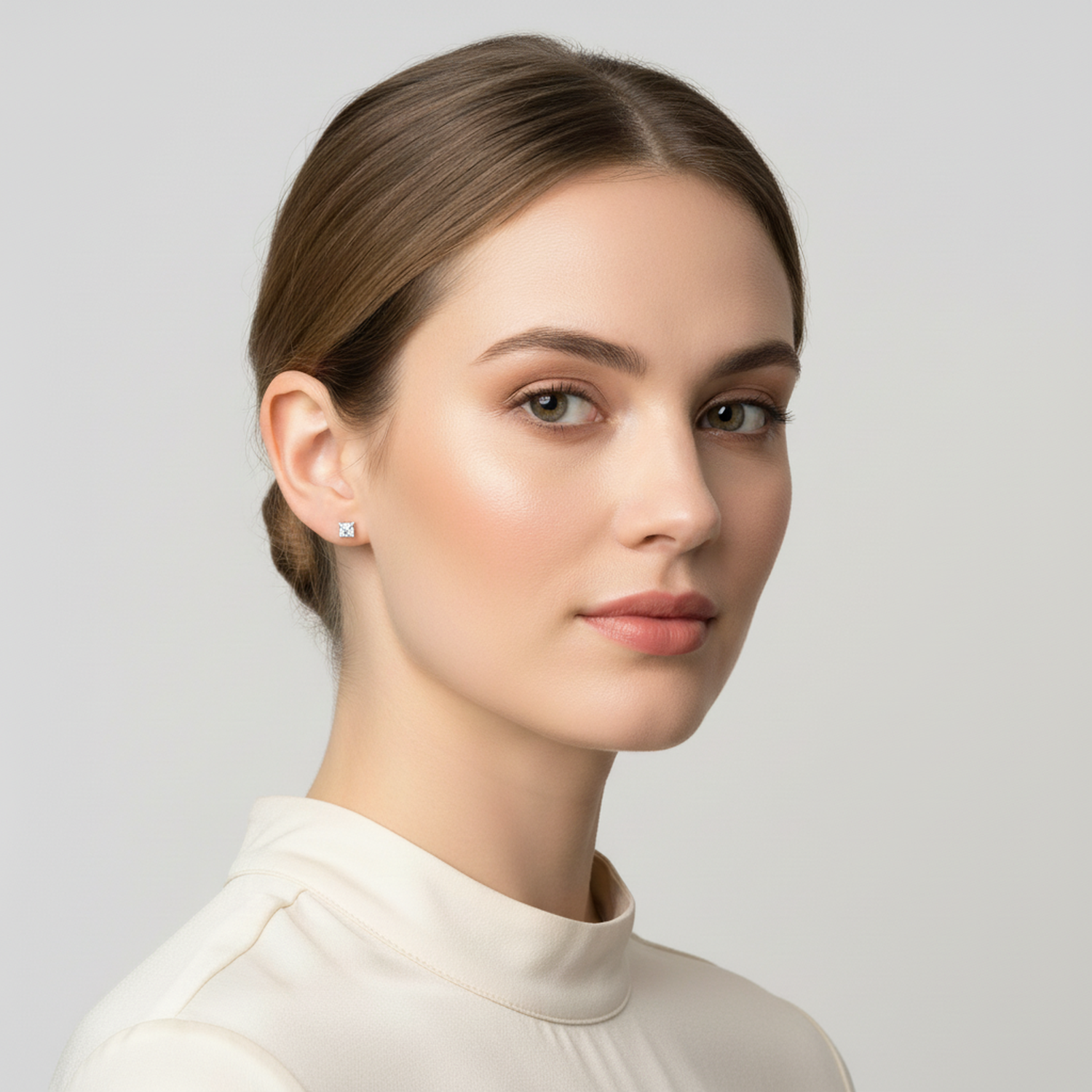 Melchior Jewellery tiny CZ stud earrings 2mm worn by woman with neat hairstyle and cream blouse