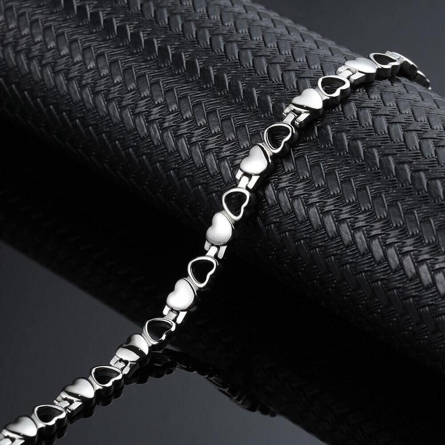 Melchior Jewellery titanium 4in1 magnetic love bracelet with linked polished heart links on textured black prop