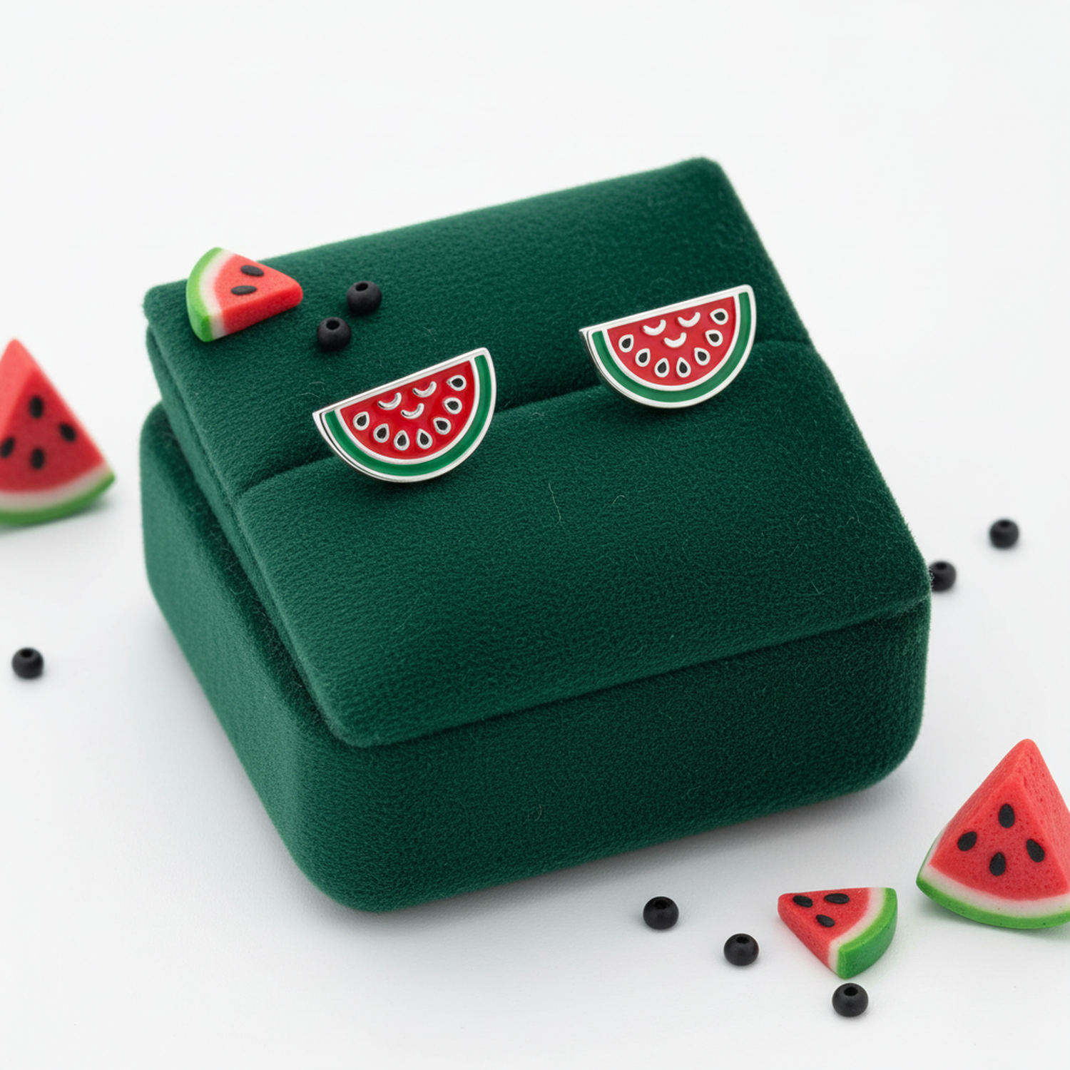 Watermelon stud earrings for kids by Melchior Jewellery with red and green enamel on green velvet box