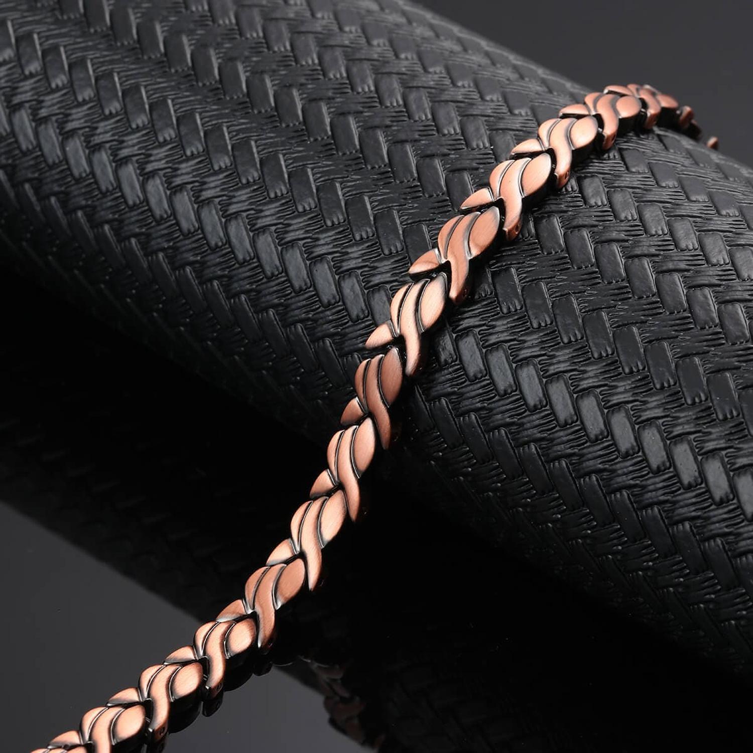 Melchior Jewellery womens copper magnetic bracelet with twisted leaf link design on black textured display