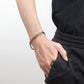 Melchior Jewellery womens copper magnetic bracelet braided chain on model wrist with casual black outfit
