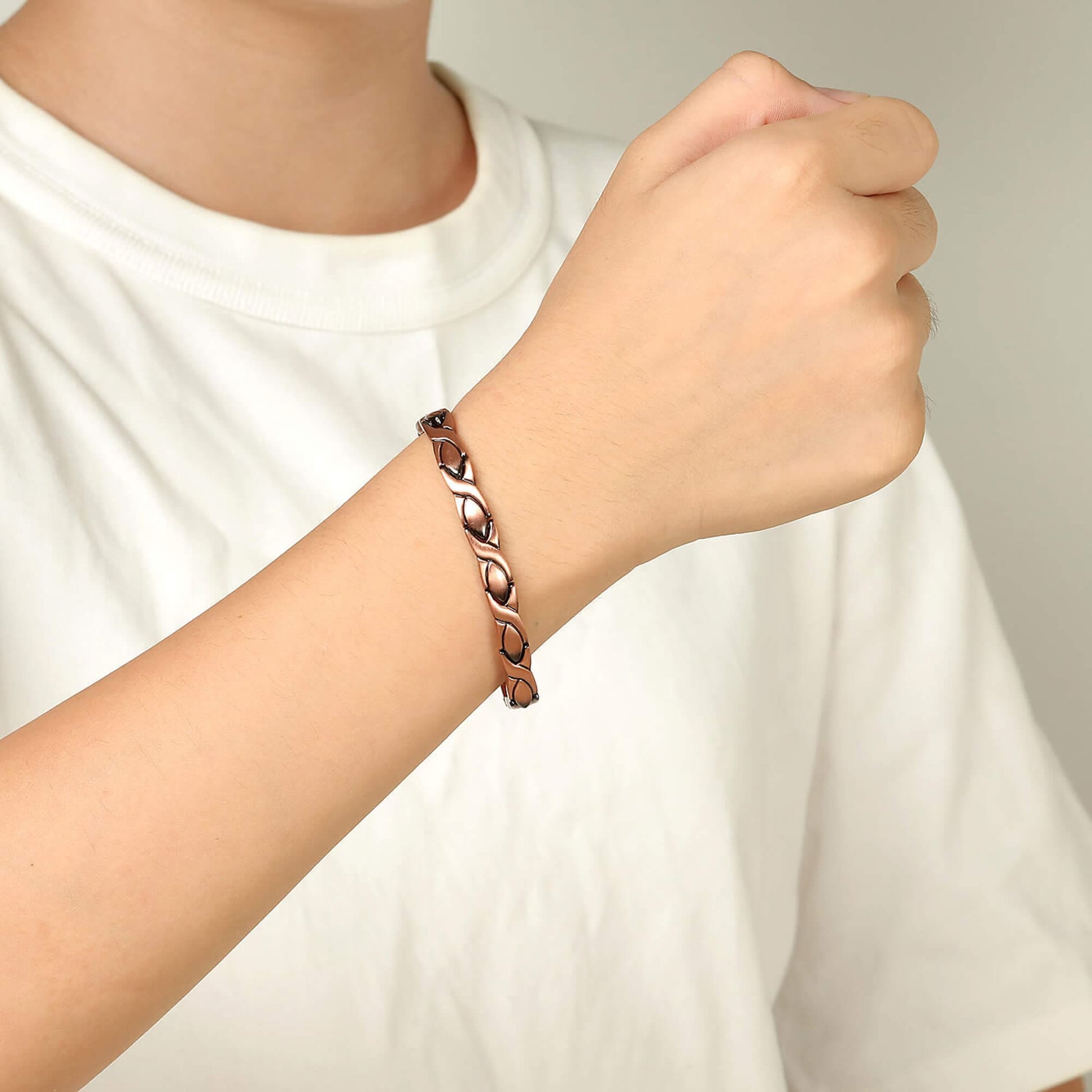 Melchior Jewellery womens copper magnetic bracelet on wrist with linked leaf design worn with white tee