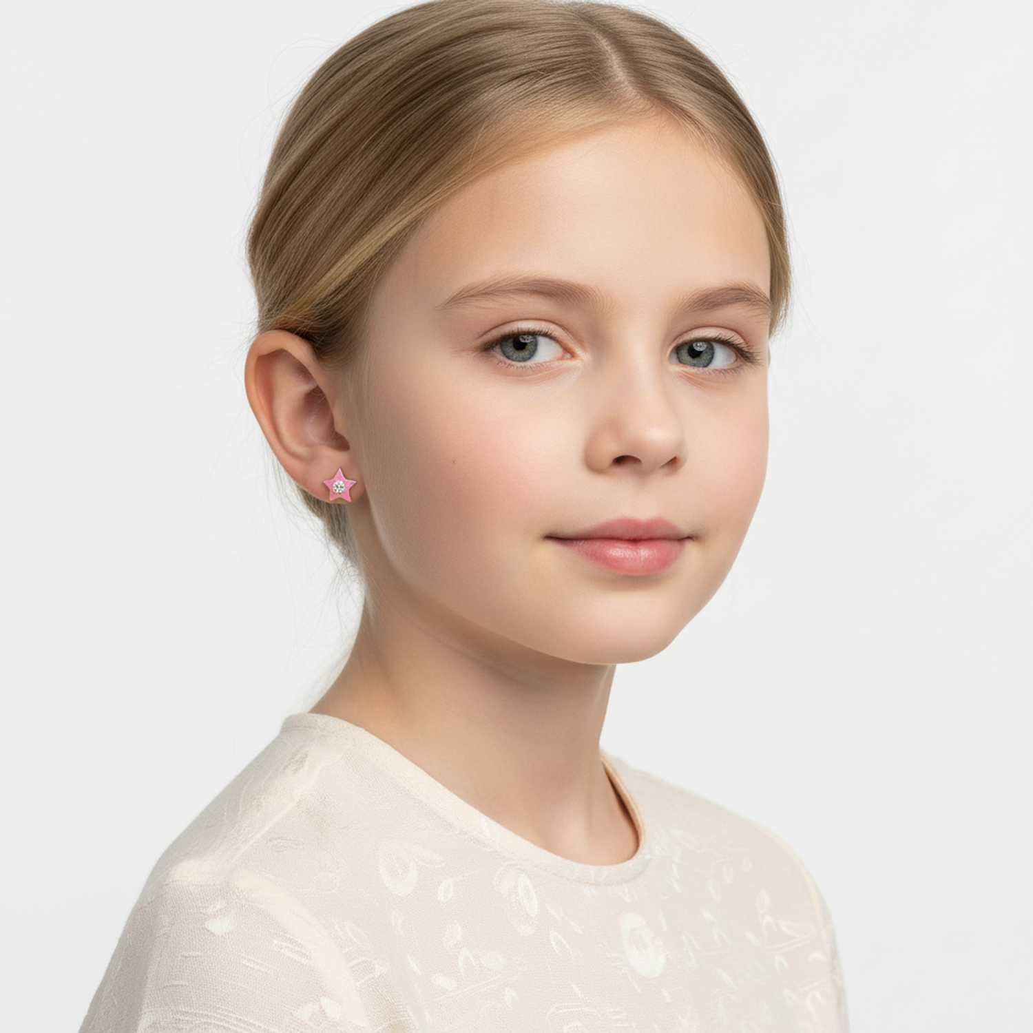 Young girl wearing kids star stud earrings silver by Melchior Jewellery with a pink star design