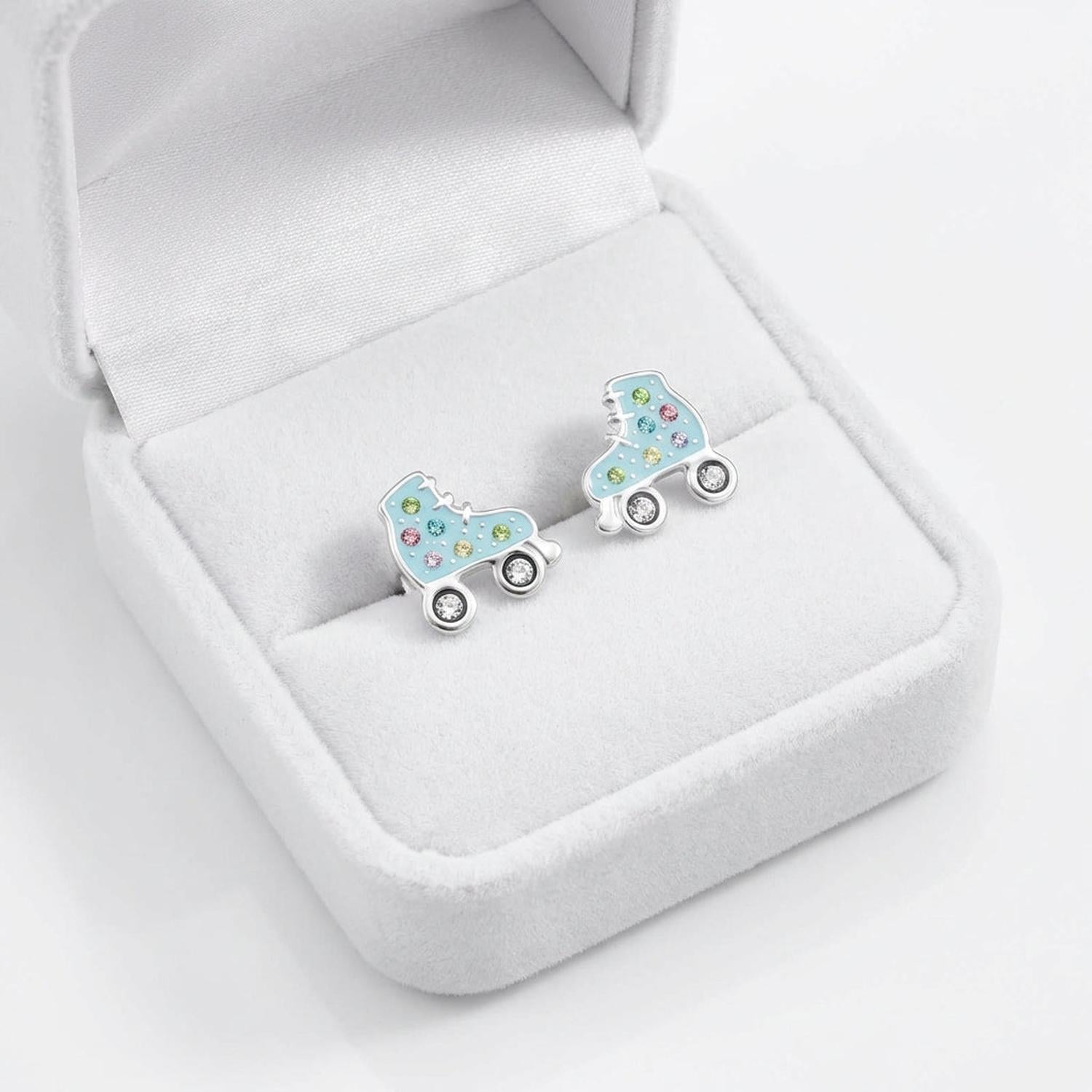 Sterling silver girls roller skate earrings by Melchior Jewellery in blue with colourful stones in a white jewellery box