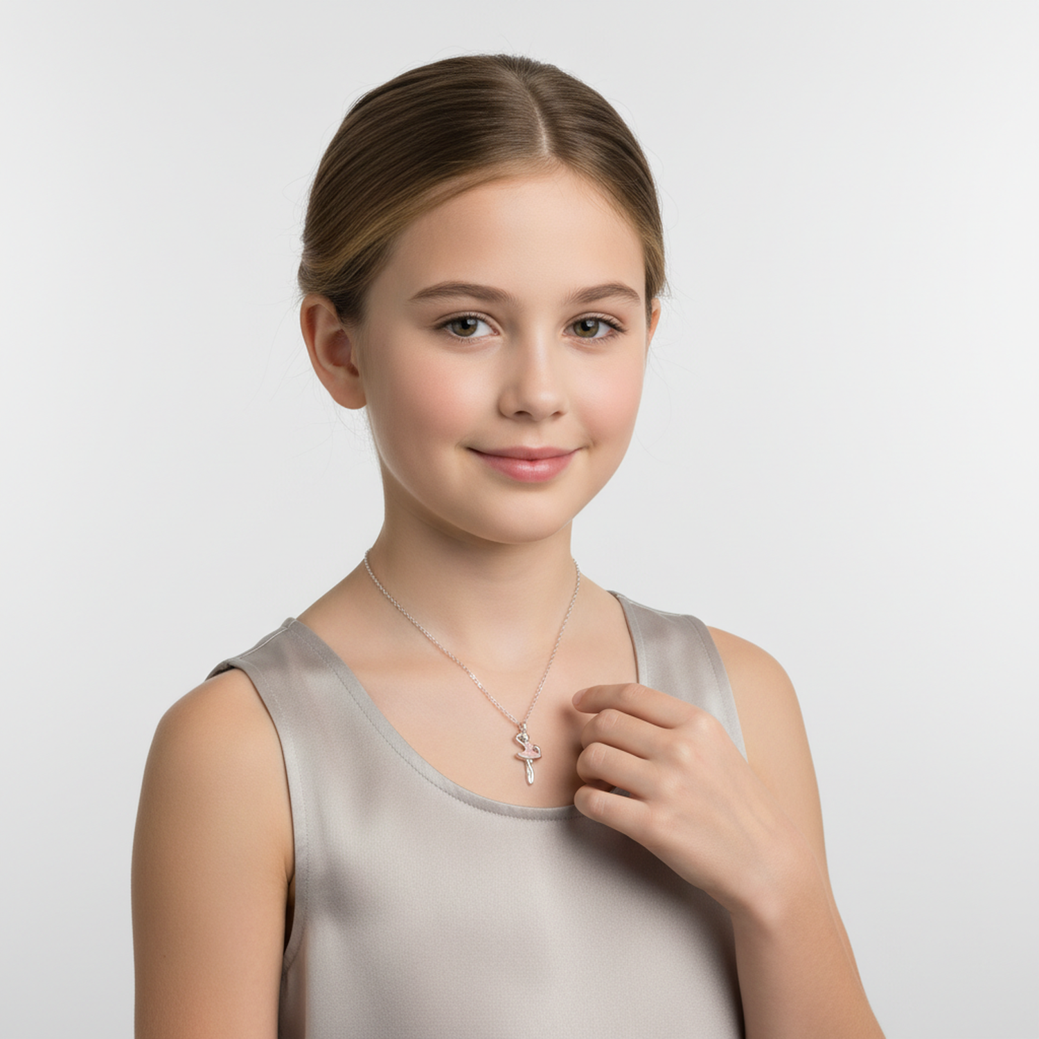 Young girl wearing a silver girls ballet dancer necklace from Melchior Jewellery with a grey satin dress