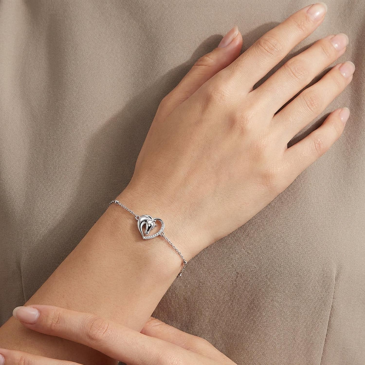 Sterling silver heritage stallion bracelet by Melchior Jewellery with a heart-shaped charm worn on wrist