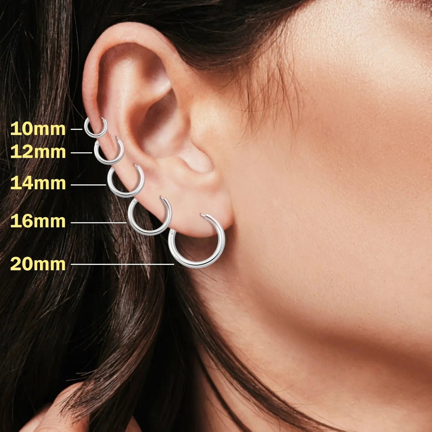 Melchior Jewellery womans earrings showing 10mm to 20mm sizes on ear in 2mm thick rhodium plated hoops