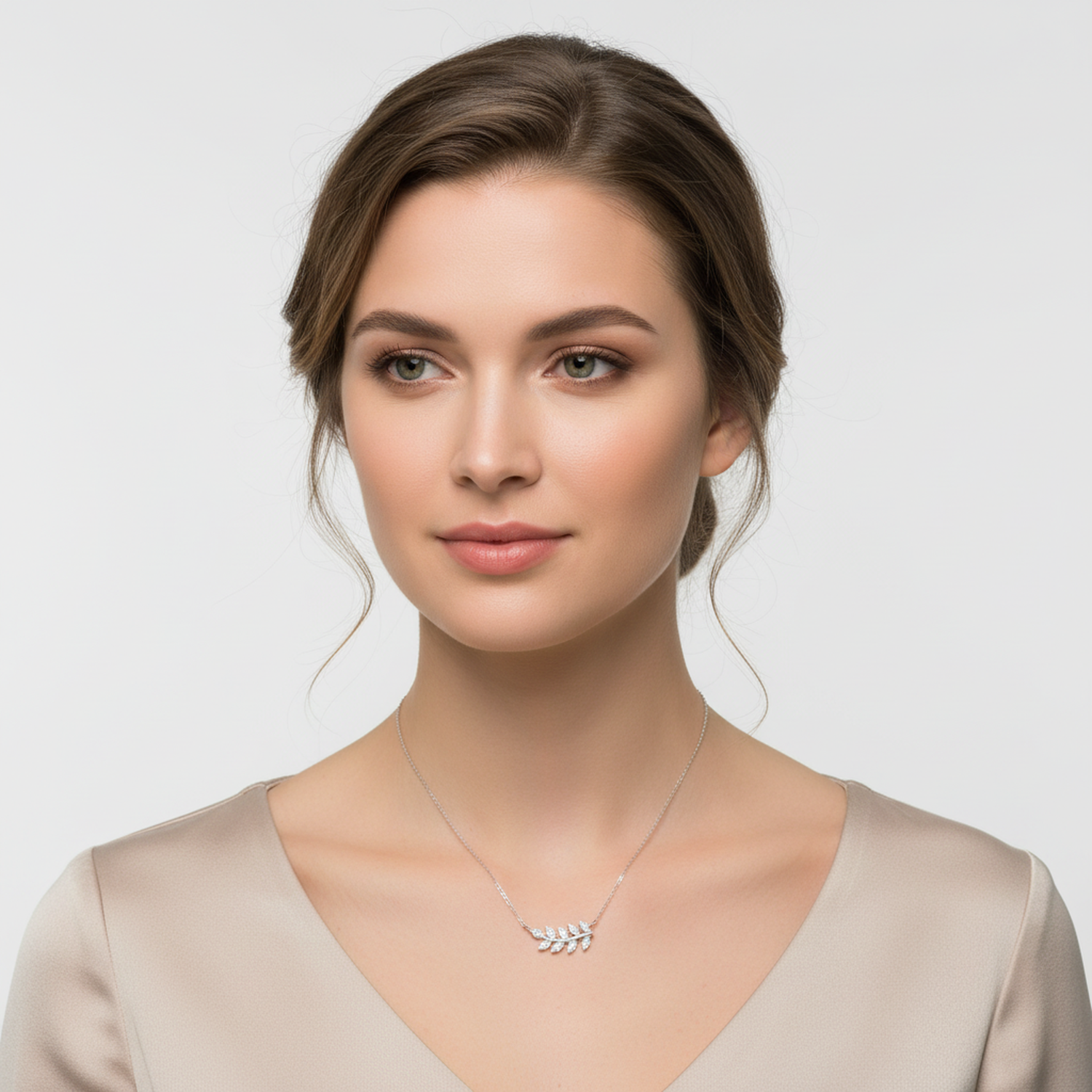 Sterling silver olive leaf necklace worn by woman with beige top from Melchior Jewellery