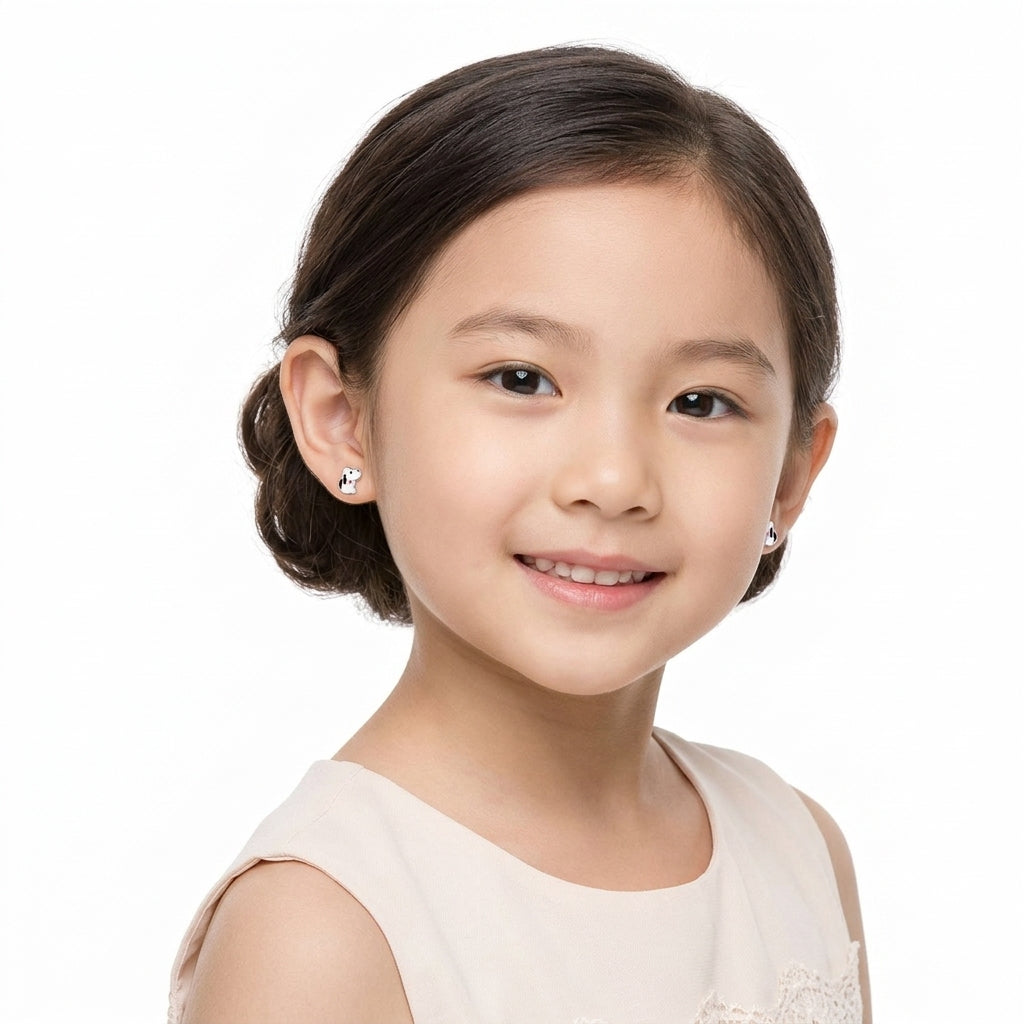 Young girl wearing silver girls dog stud earrings with black and white enamel detail by Melchior Jewellery