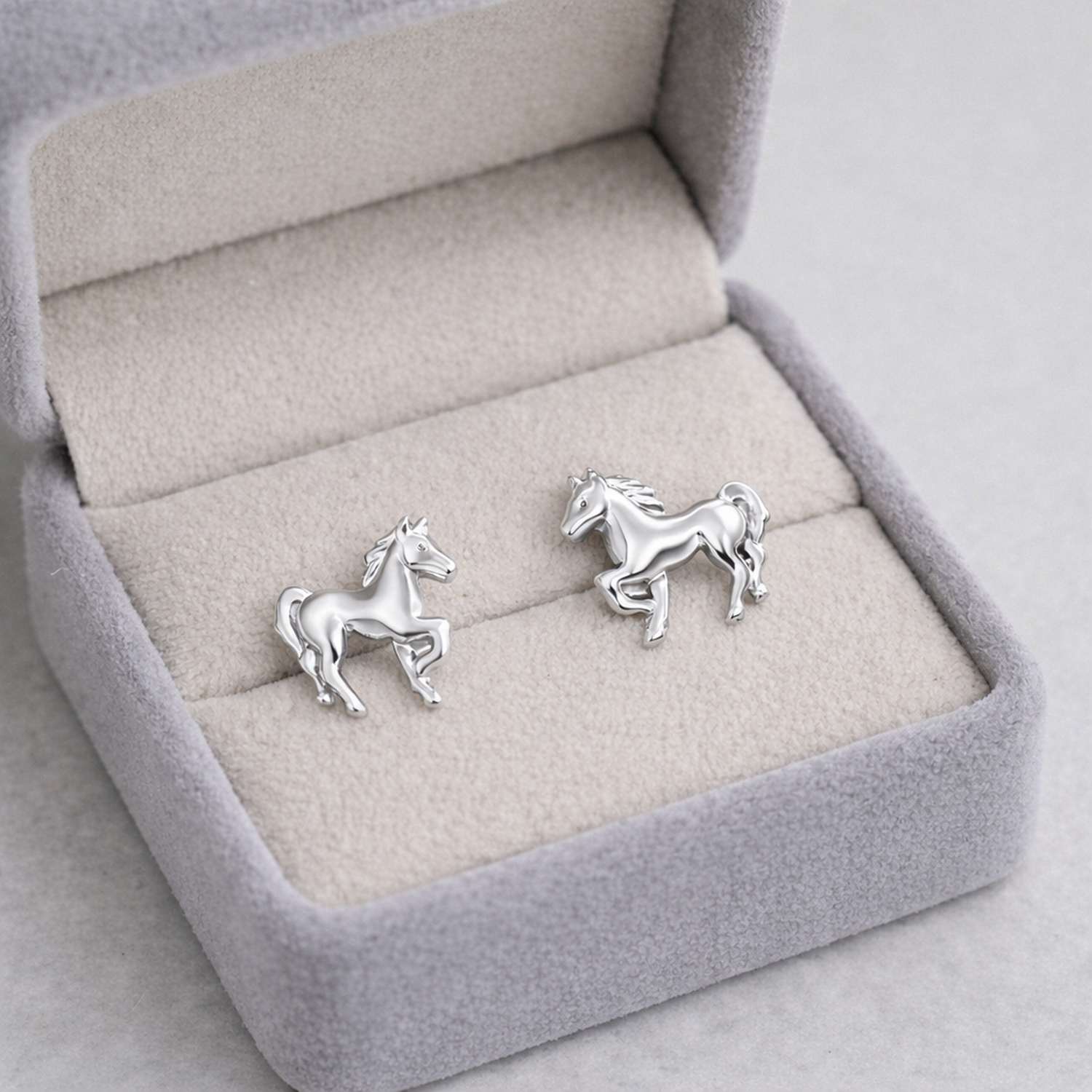 Premium kids silver animal earrings shaped like horses in a soft grey jewellery box from Melchior Jewellery
