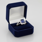 Sterling silver blue sapphire ring with square-cut gemstone and diamond accents in a navy velvet box