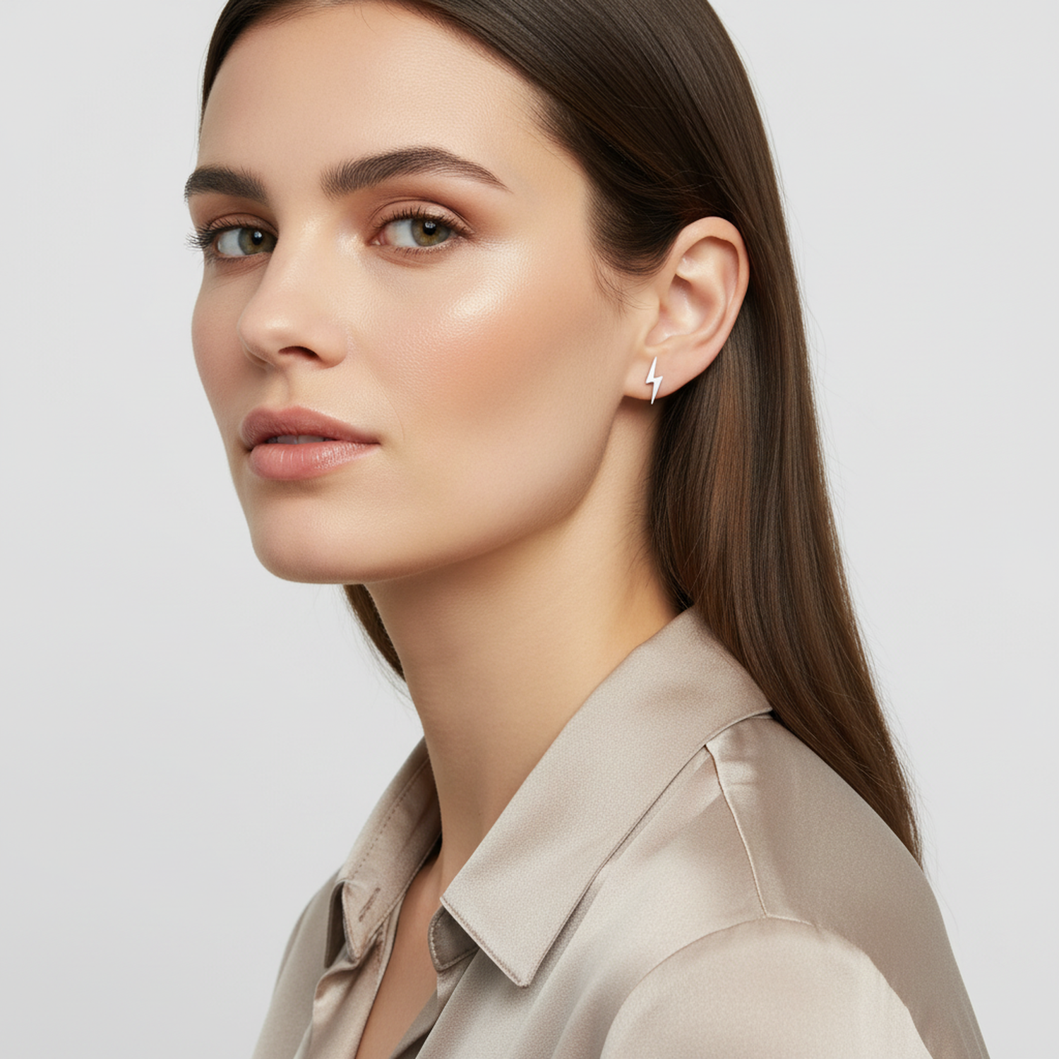 Melchior Jewellery sterling silver lightning bolt earrings worn by woman with brown hair and neutral silk shirt