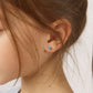 Child wearing blue heart-shaped sterling silver screw back earrings for girls from In Season Jewellery