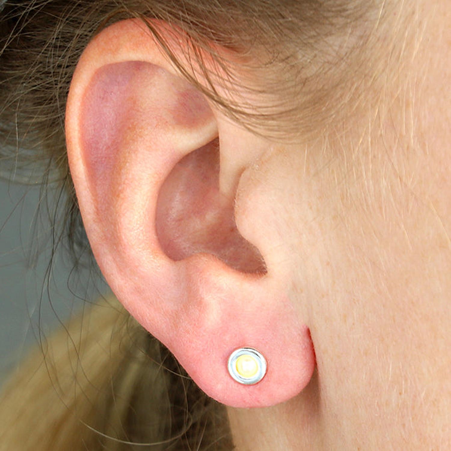 Woman wearing Melchior Jewellery cultured pearl earrings silver stud with elegant design