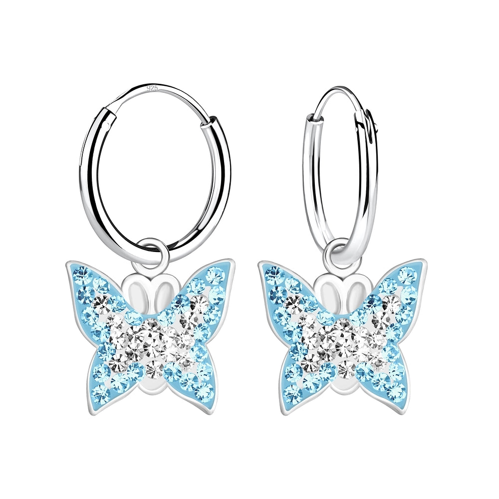Girls silver hoop earrings with butterfly charms adorned with blue and clear crystals by Melchior Jewellery