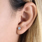 Close-up of a round cut cubic zirconia earrings gold worn on ear by Melchior Jewellery