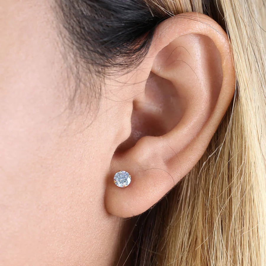 Close-up of a round cut cubic zirconia earrings gold worn on ear by Melchior Jewellery