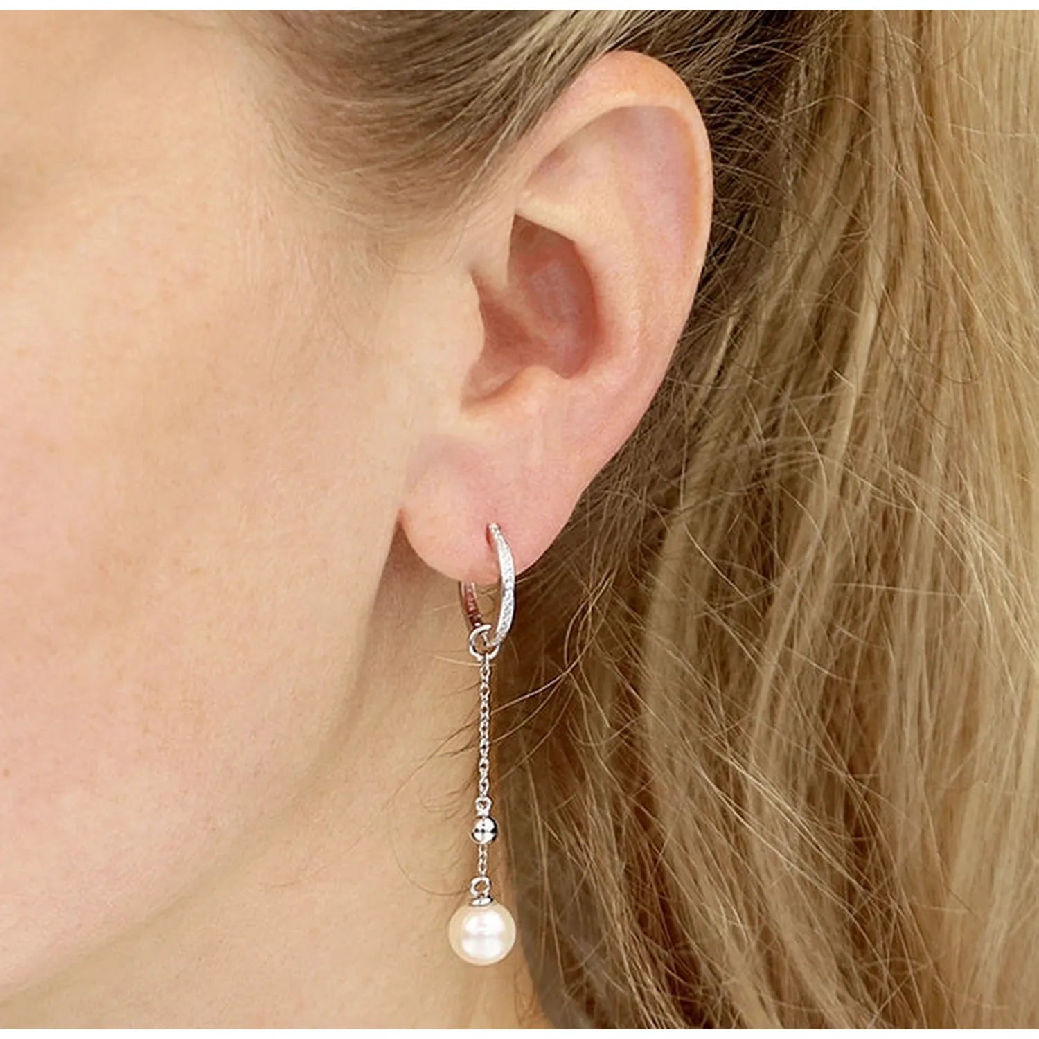 Melchior Jewellery sterling silver pearl drop earrings with delicate chain and white pearl on model